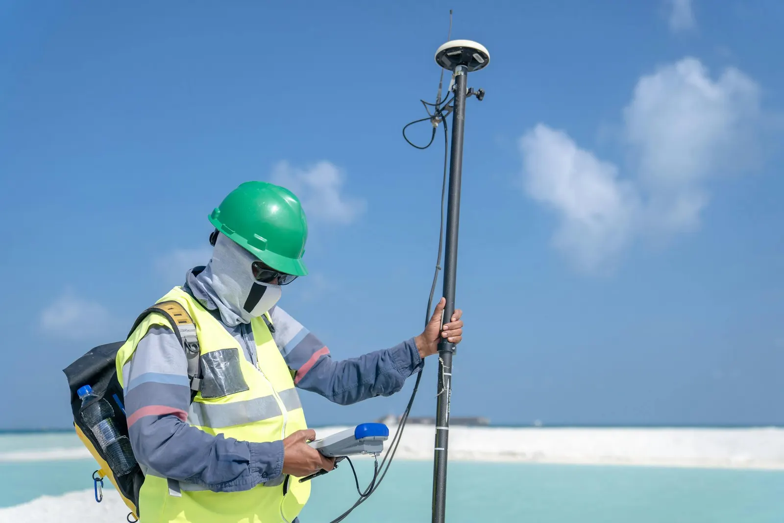 A total station set up on a tripod over a control mark on a construction site, ready to stake design coordinates.